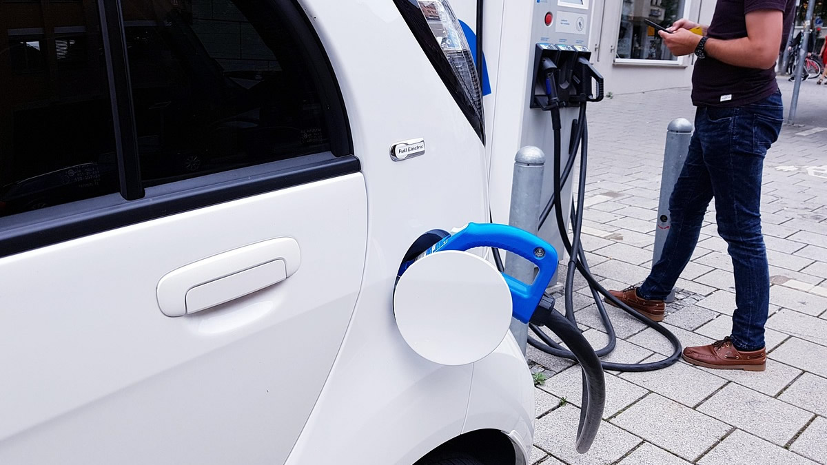 Veículo elétrico conectado a uma estação de carregamento em posto de recarga